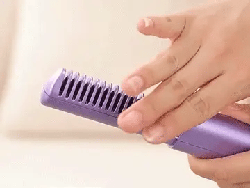 Portable Cordless Hair Straightener Comb being held, showcasing its unique comb design for easy hair styling.